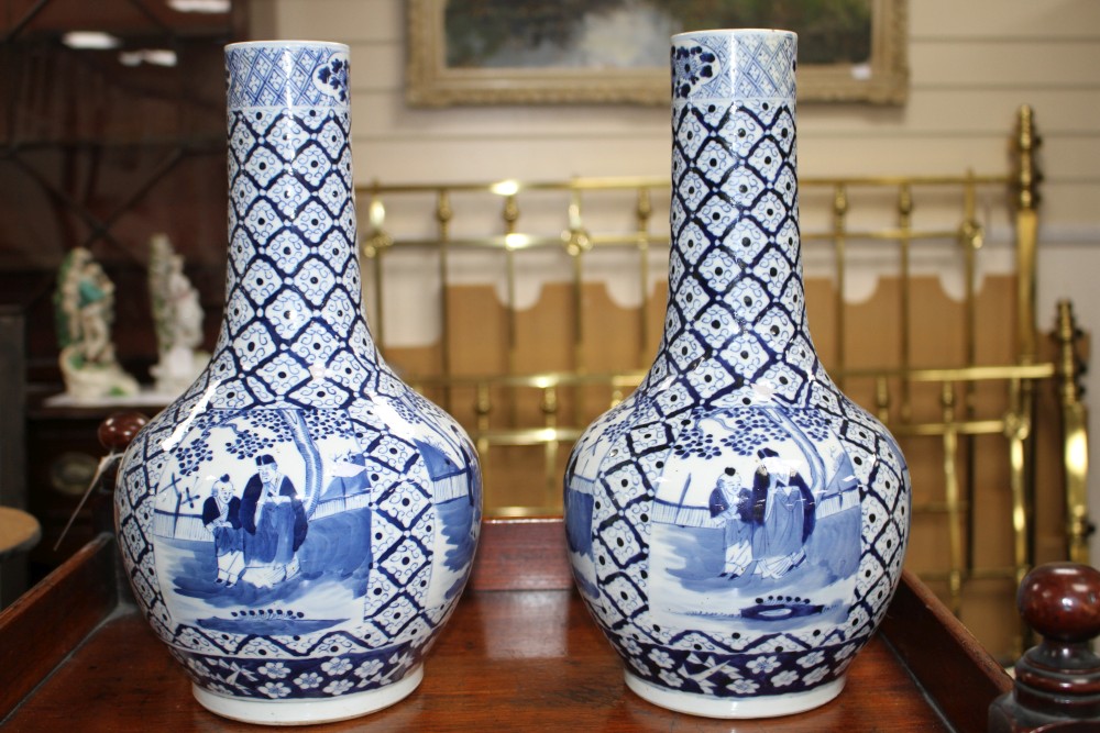 A pair of 19th century Chinese blue and white vases, decorated with panels of figures in gardens, four character marks, height 34.5cm